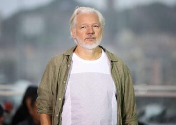 مؤسس موقع “ويكيليكس” يرتدي قميصًا يحمل أسماء آلاف الأطفال الذين استشهدوا في غزة  